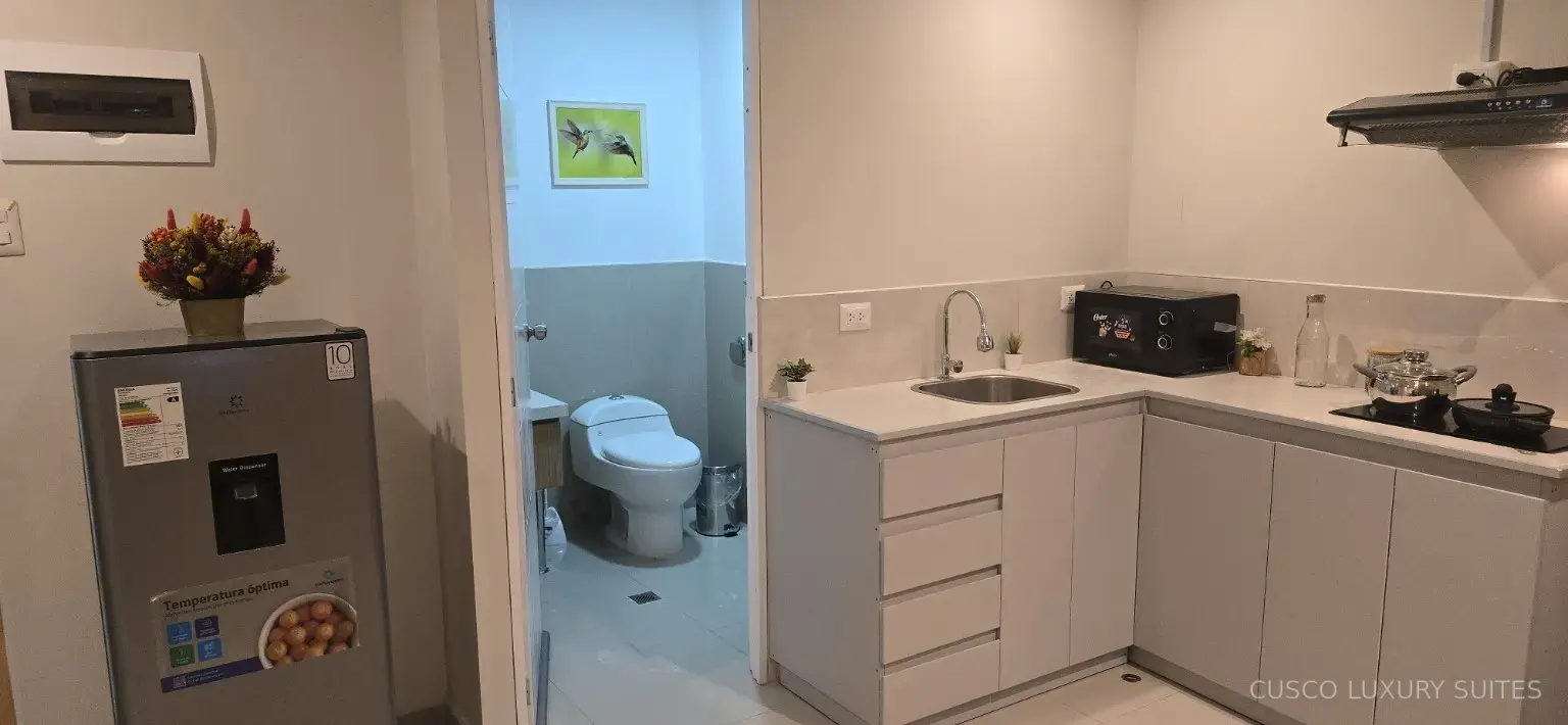 KILLA SUITE kitchen with refrigerator beside the full bathroom