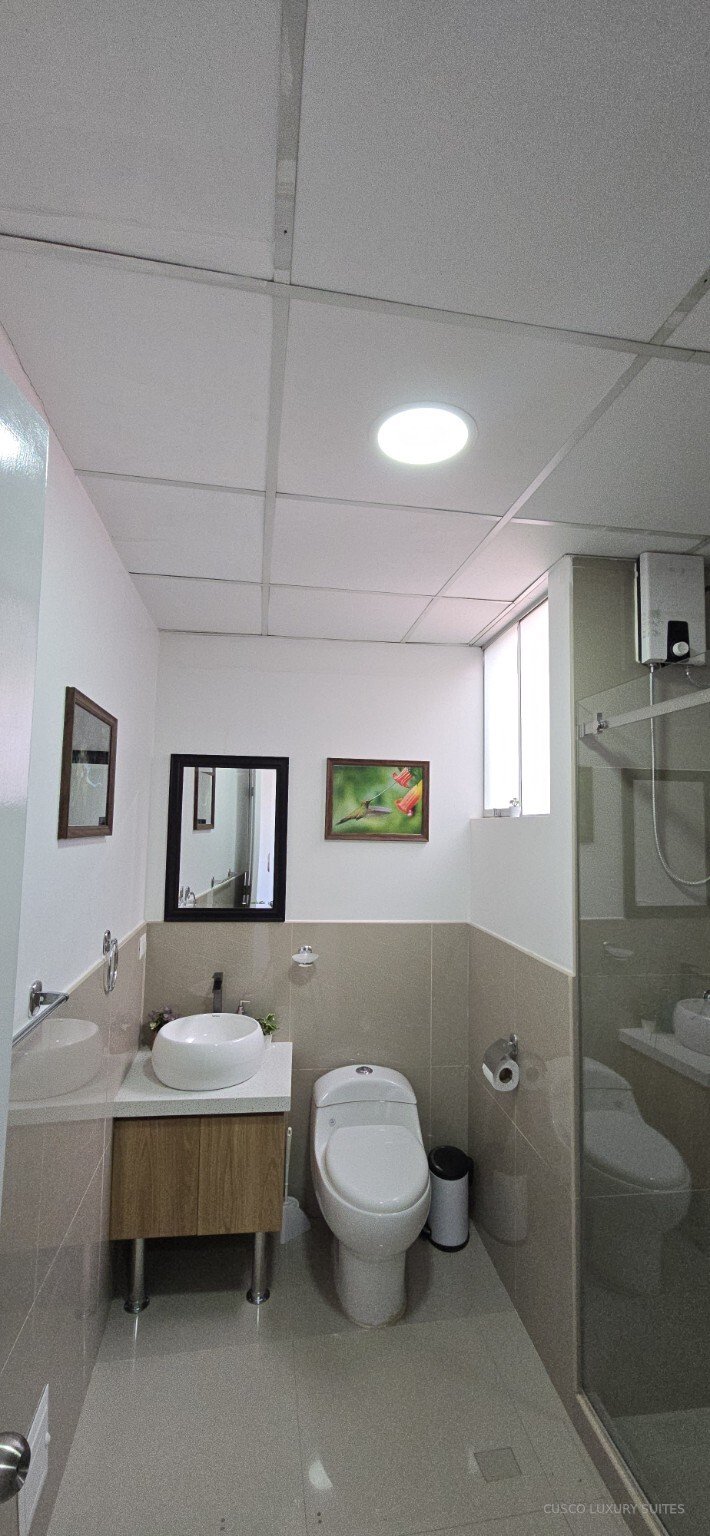 SUMAQ SUITE full bathroom with glass shower and modern vanity