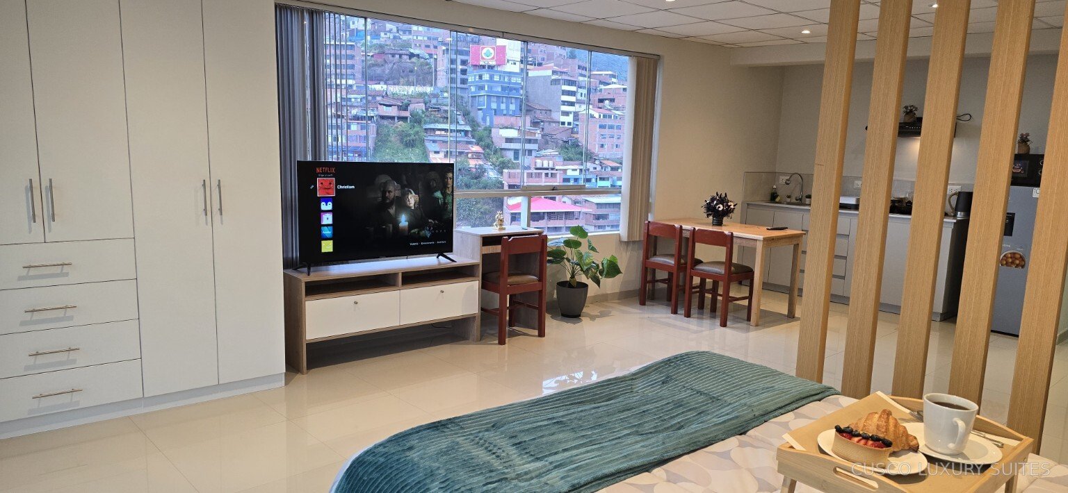 SUMAQ SUITE bedroom with Smart TV, dining area and equipped kitchen