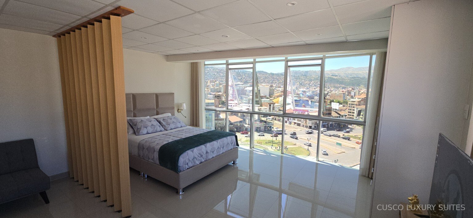 Bright SUMAQ SUITE bedroom with a panoramic daytime view of Cusco