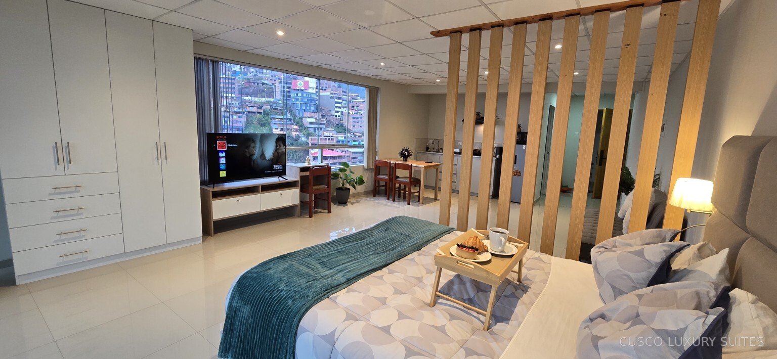 SUMAQ SUITE bedroom opening onto the living, dining and kitchen areas